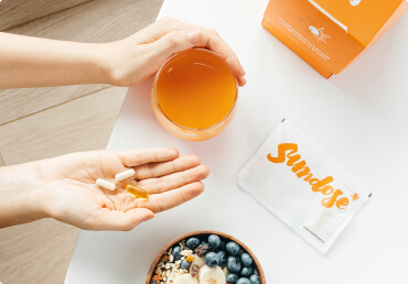 Glass of Sundose supplement and pills